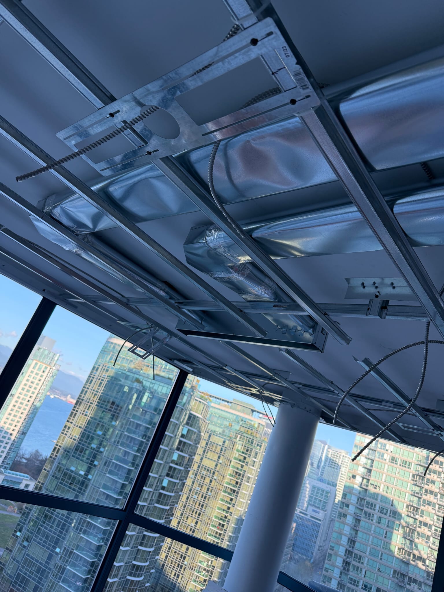Ductwork installation with Vancouver, British Columbia skyline